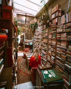 a woman sitting in a room filled with lots of books