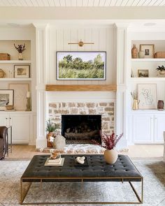 a living room filled with furniture and a fire place in front of a stone fireplace