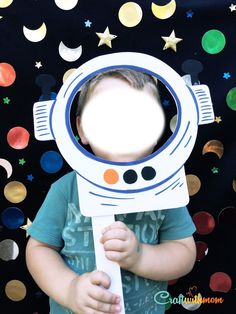 a young boy is holding a cardboard toy in front of his face