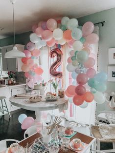 a table topped with lots of balloons and plates