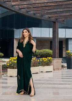 Deep forest green Velvet Kaftan delicately handworked with dabka, nakshi and zardozi on the neckline, shoulder slits, sleeves and front and back hemline and side slits. V-neck Kurta With Dabka Work For Party, Elegant Long Dress With Cutdana, Bollywood Style Formal Dress With Cutdana, Festive Evening Kurta With Zari Work, Evening Anarkali Kurta With Traditional Drape, Traditional Floor-length Evening Kurta, Elegant Designer Green Gown, Formal Green Dupatta With Dabka Detail, Evening Eid Kurta With Zari Work