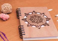 a wooden notebook sitting on top of a table next to some string and beads,