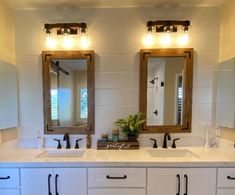 a bathroom with double sinks and two mirrors