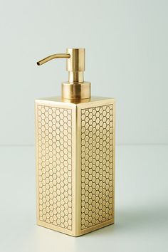 a golden soap dispenser on a white surface