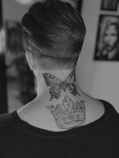 a woman with a butterfly and crown tattoo on her neck