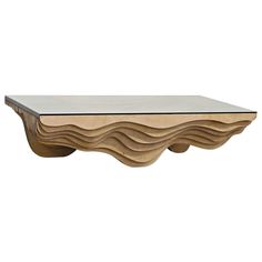 a wooden table with wavy shapes on it's sides and a glass top in the middle