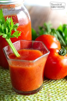 homemade tomato juice in a small glass next to tomatoes