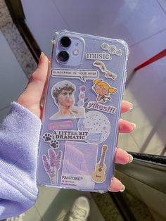 a person holding up a phone case with stickers on it's back and an image of a woman