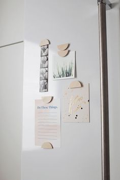 a refrigerator door with magnets and pictures on the front, along with a metal pole