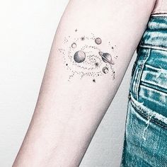 a woman's arm with planets and stars tattoo on the left side of her arm