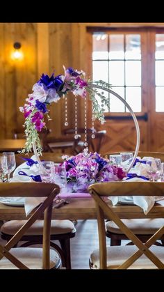 the table is set with purple and white flowers