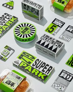 various packagings and stickers on top of a white table with green lettering that reads eat super park