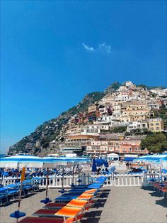 the beach is lined with umbrellas and chairs