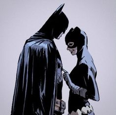 batman and catwoman are standing next to each other