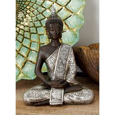 a buddha statue sitting on top of a wooden table