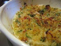 a casserole dish with broccoli and cheese in it sitting on a table