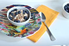 a bowl of oatmeal with blueberries and almonds on a plate