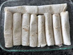 several tortillas sitting in a glass dish on a counter