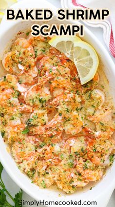 baked shrimp scampp in a white bowl with lemon wedges and parsley