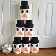 a stack of toilet paper snowmen sitting on top of a wooden floor