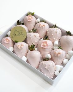 a box filled with lots of pink and white chocolate covered strawberries on top of a table