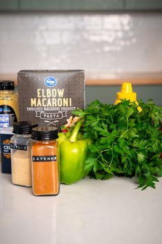 various spices and seasonings on a countertop next to green pepper, parsley