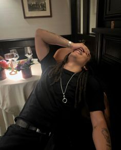 a man with dreadlocks sitting at a table