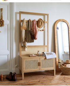 a wooden cabinet sitting next to a mirror on top of a hard wood floor in front of a white wall