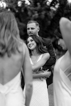 a bride hugging her groom in front of some other people