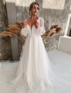 a woman in a white wedding dress posing for the camera with her hands on her hips