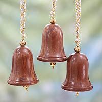 two wooden bells hanging from chains on a window