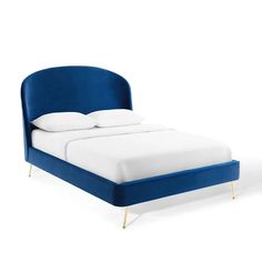 a bed with blue upholstered headboard and white pillows on top of it