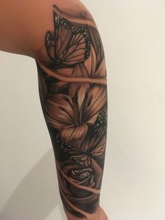 a woman's arm with flowers and butterflies on it