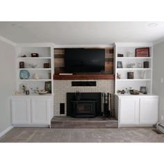 a living room filled with furniture and a flat screen tv mounted on a wall above a fireplace