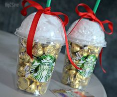 two starbucks cups filled with gold coins and wrapped in red ribbon are sitting on a table