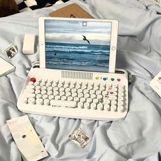 an open laptop computer sitting on top of a bed next to a keyboard and mouse