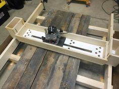 a machine that is sitting on top of some wood planks in a room with other tools