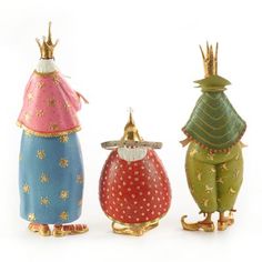 three colorful figurines are standing next to each other on a white surface and one is wearing a crown