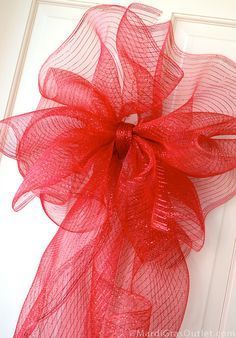 a red bow with the words, 21 inch bow on it in front of a white door