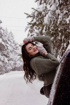 a woman is posing in the snow with her arms behind her head