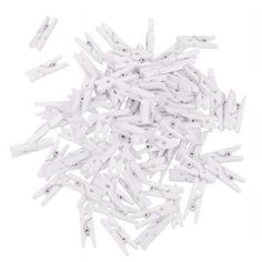 white plastic clothes pegs are scattered on a white surface, including one in the middle