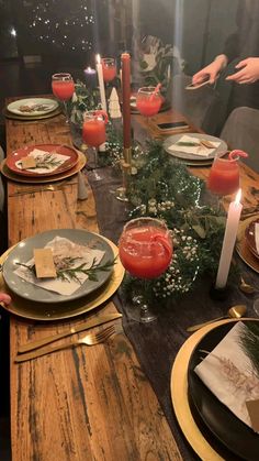 a long wooden table with plates and candles