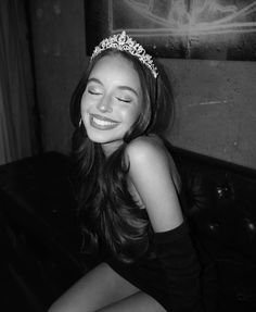 a woman wearing a tiara sitting on a couch