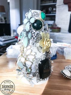 a table topped with lots of jewelry on top of a wooden counter next to other items