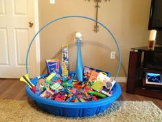 a blue basket filled with toys on top of a rug