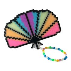 Add a touch of rainbow to your festival gear collection with this beautiful Glow in the Dark Perler Kandi Hand Fan Bracelet Wristlet. It is handcrafted with high-quality beads and features a beaded bracelet design that is perfect for any wrist size. The Byte Size Kandi brand ensures the best quality and design for your jewelry collection. This bracelet is perfect for anyone who loves to stand out in the crowd. The rainbow colors will glow in the dark and make you shine. The bracelet is perfect for any festival or party and will make a great addition to any costume. The beaded design is stylish and comfortable to wear all day long. Get your hands on this exclusive bracelet now! Rainbow Beaded Bracelets For Rave Gift, Rainbow Beaded Bracelets For Gifts, Rave Style, Rainbow Colored Rave Style Beaded Bracelets For Gifts, Handmade Multicolor Rave Wristband, Multicolor Rave Wristband As Gift, Handmade Rave Stretch Bracelet As Gift, Handmade Stretch Bracelet For Rave Gift, Handmade Colorful Stretch Bracelet For Festival, Handmade Stretch Bracelet For Gift