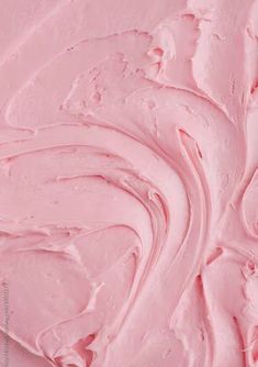 a close up view of pink icing on a cake