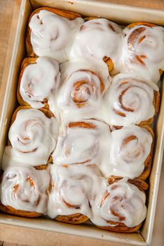 a pan filled with cinnamon rolls covered in icing