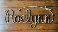 the word raeslynn written in rope on a wooden surface