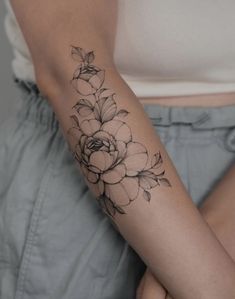 a woman with a flower tattoo on her arm